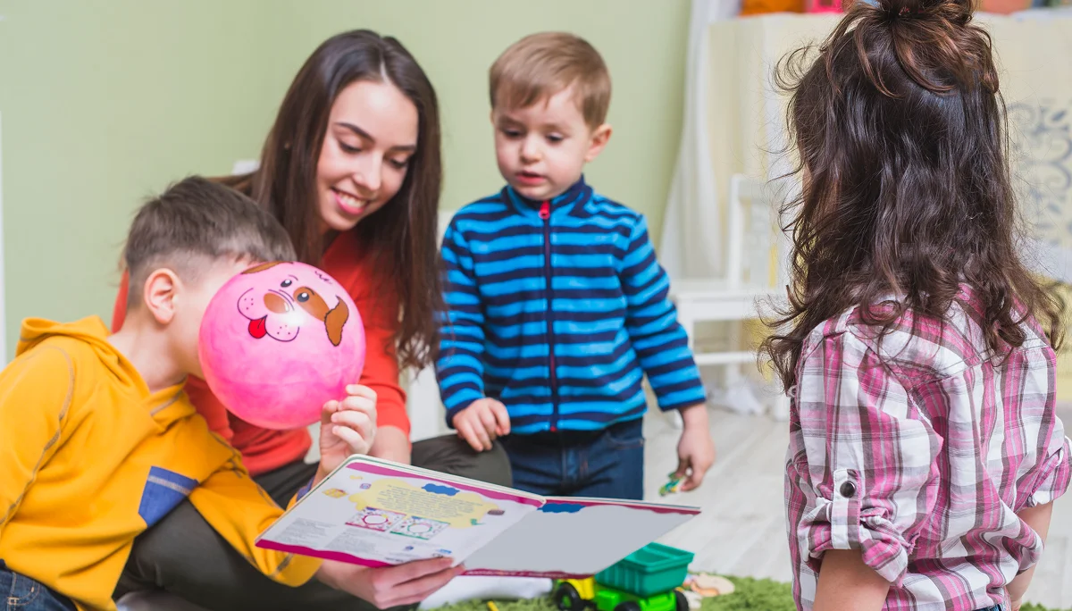 A daycare teacher is teaching the children at Panda Bear Academy in Houston, Texas
