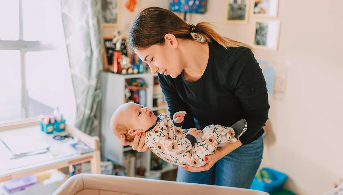 A teacher of Panda Bear Academy is taking care of an infant.